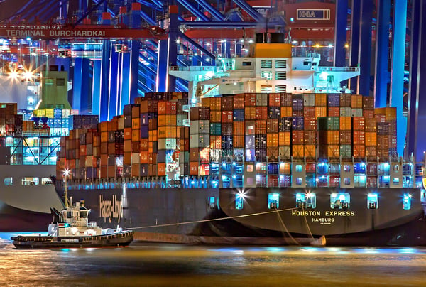 A cargo ship in the middle of the sea at night